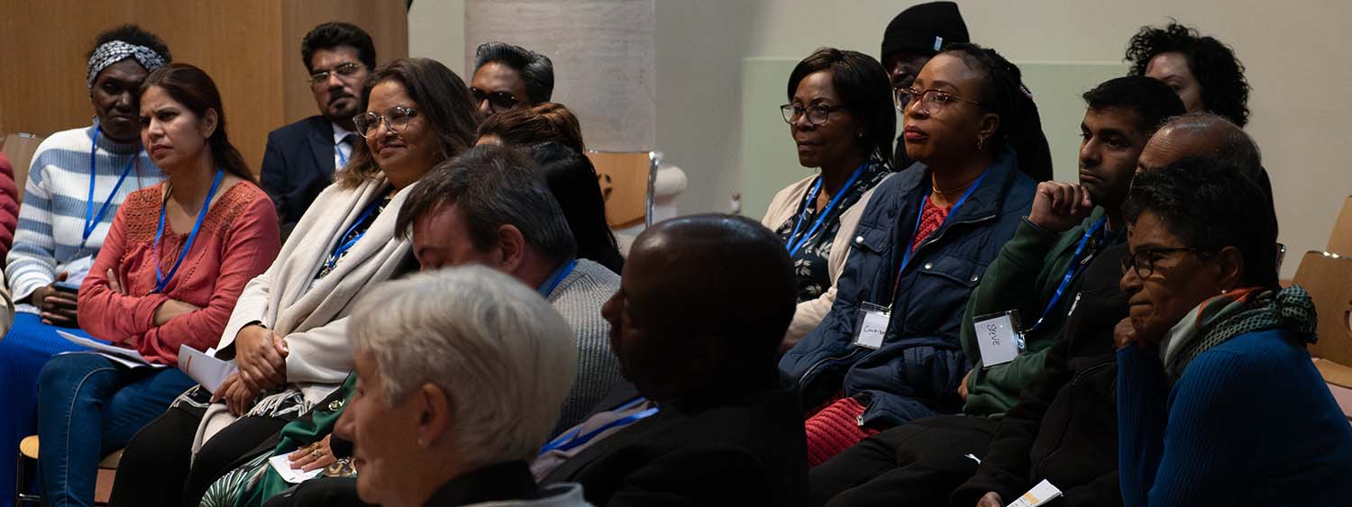 A group of clergy and laity listen at a conference