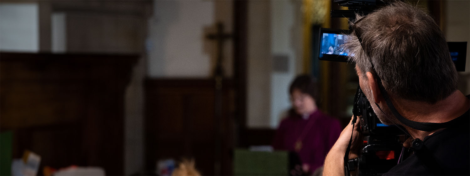 A cameraman films a church service