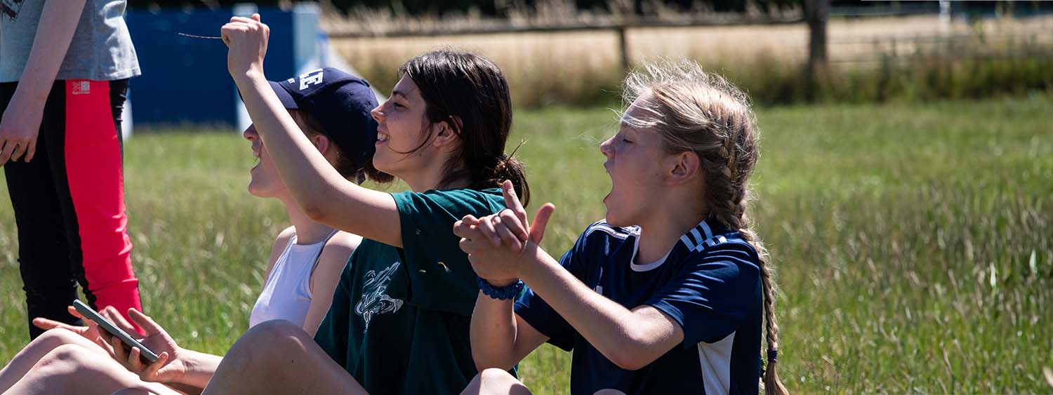 Young people cheer each other on at an outdoor event